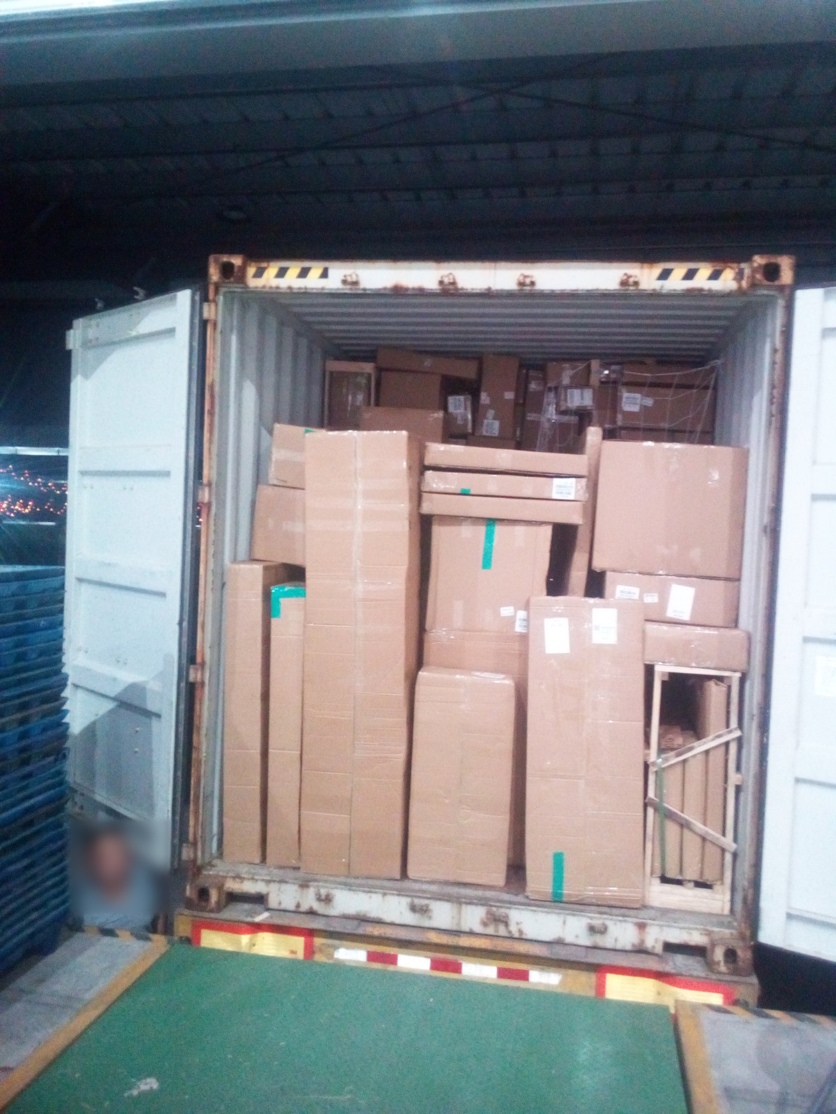 Cartons of mixed sizes stacked in a container doorway during loading